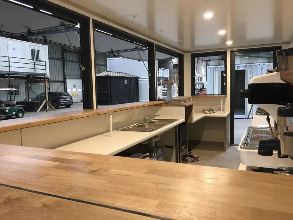 Conteneur de 6 mètres (20 pieds) abritant un café, au design très épuré